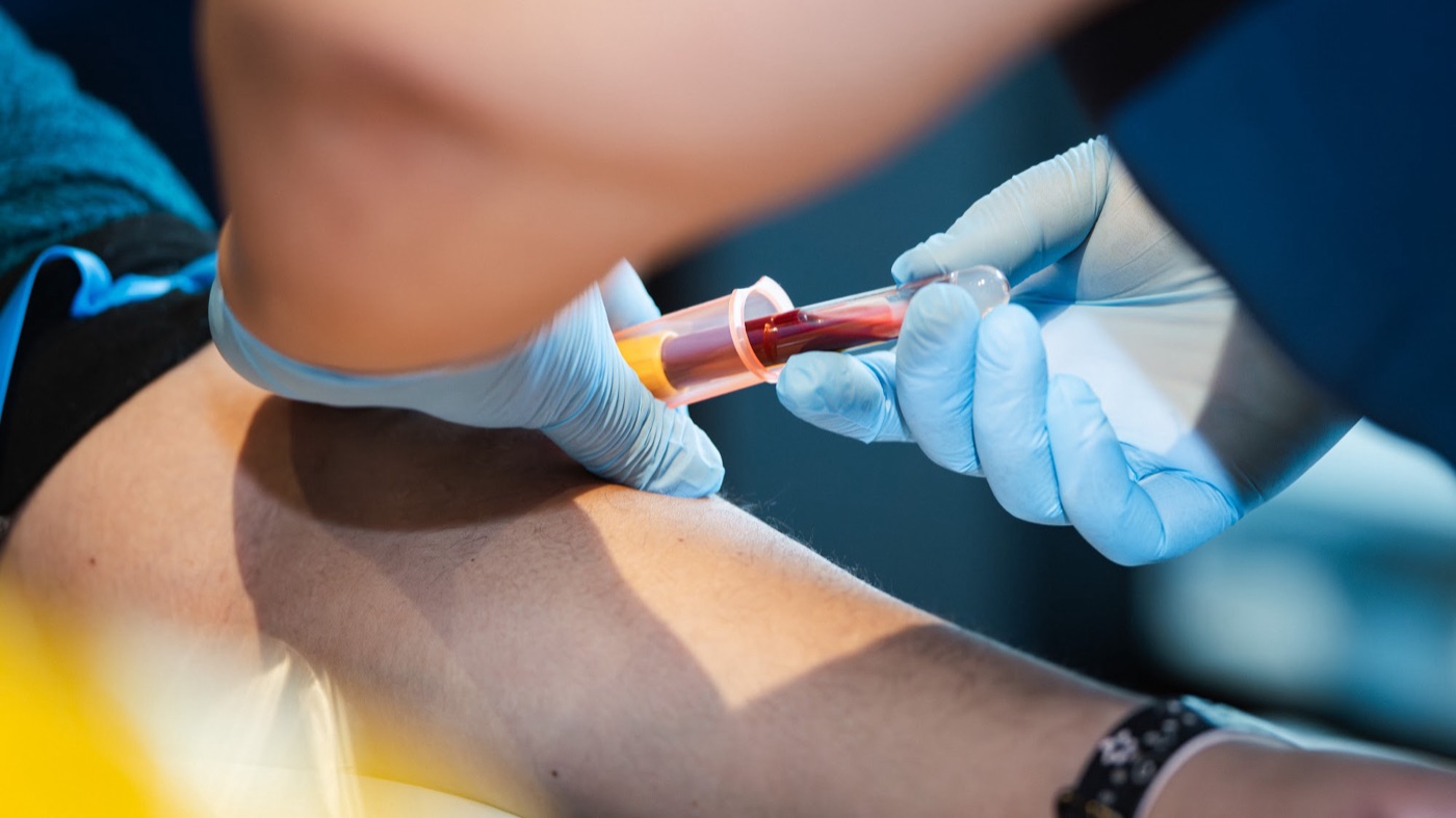 Tecnóloga médica tomando una muestra de sangre a un paciente en su domicilio