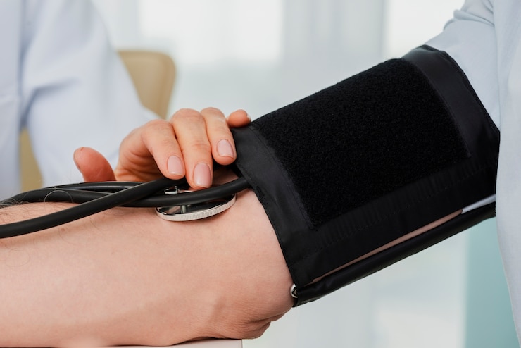 Control de presión arterial con manguito y estetoscopio en el brazo del paciente