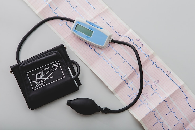 Trazado de electrocardiograma junto a un tensiómetro de brazo