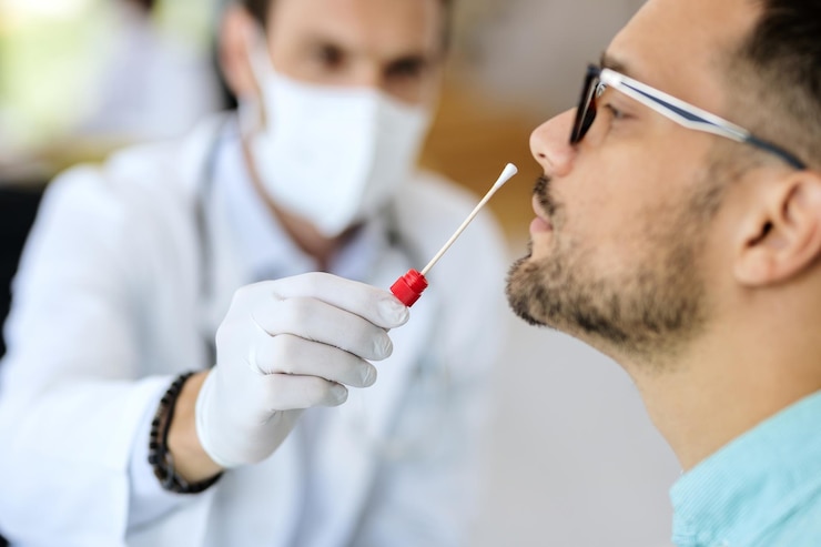 Profesional con mascarilla toma una muestra con hisopo a un hombre
