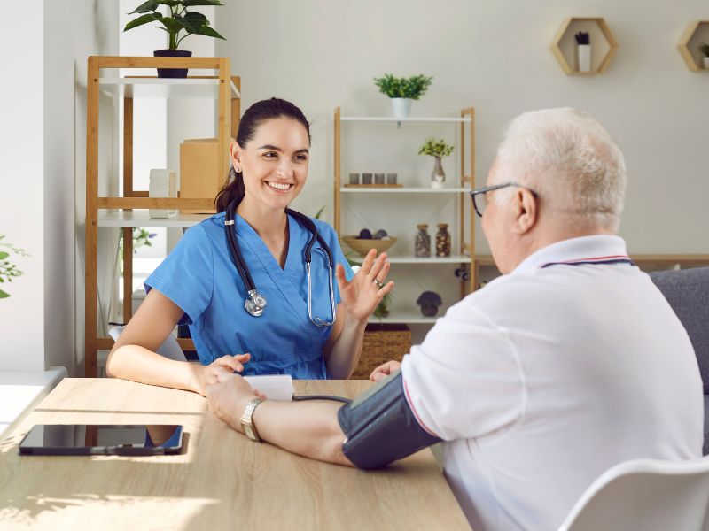 Profesional de salud mide la presión arterial a un adulto mayor